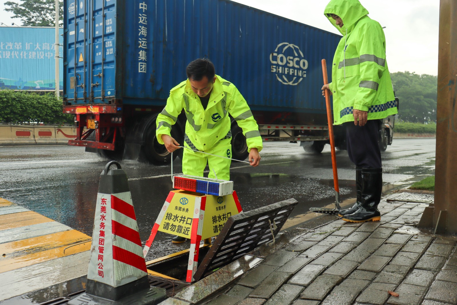 第四分公司运营工作部运维人员在水乡大道九曲村路口的雨水篦设置警示架.jpg
